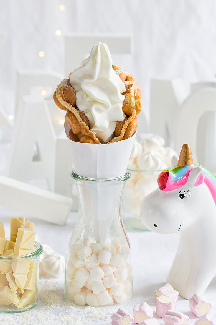 A bubble waffle with frozen yoghurt next to a unicorn decoration