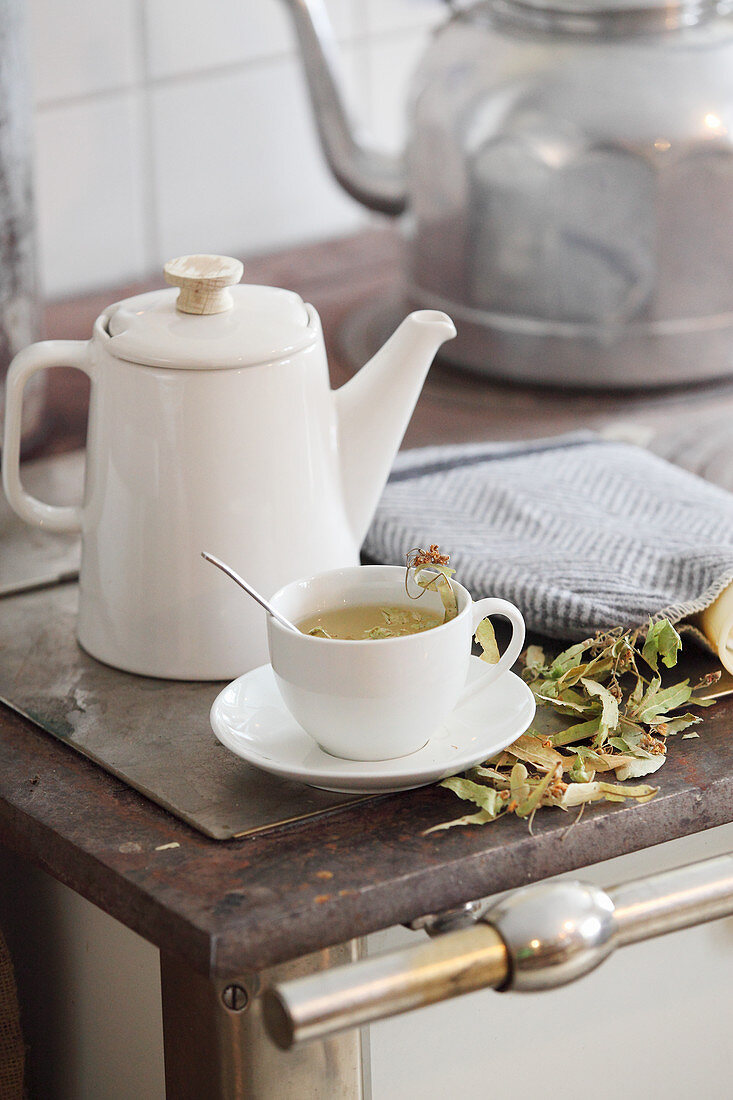 Teekessel, Teekanne und Teetasse auf altem Küchenherd