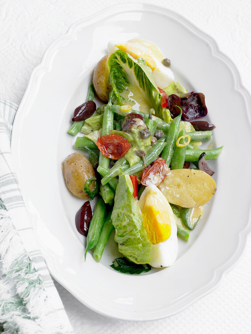 Nicoise salad with potatoes, dried tomatoes, green beans and egg