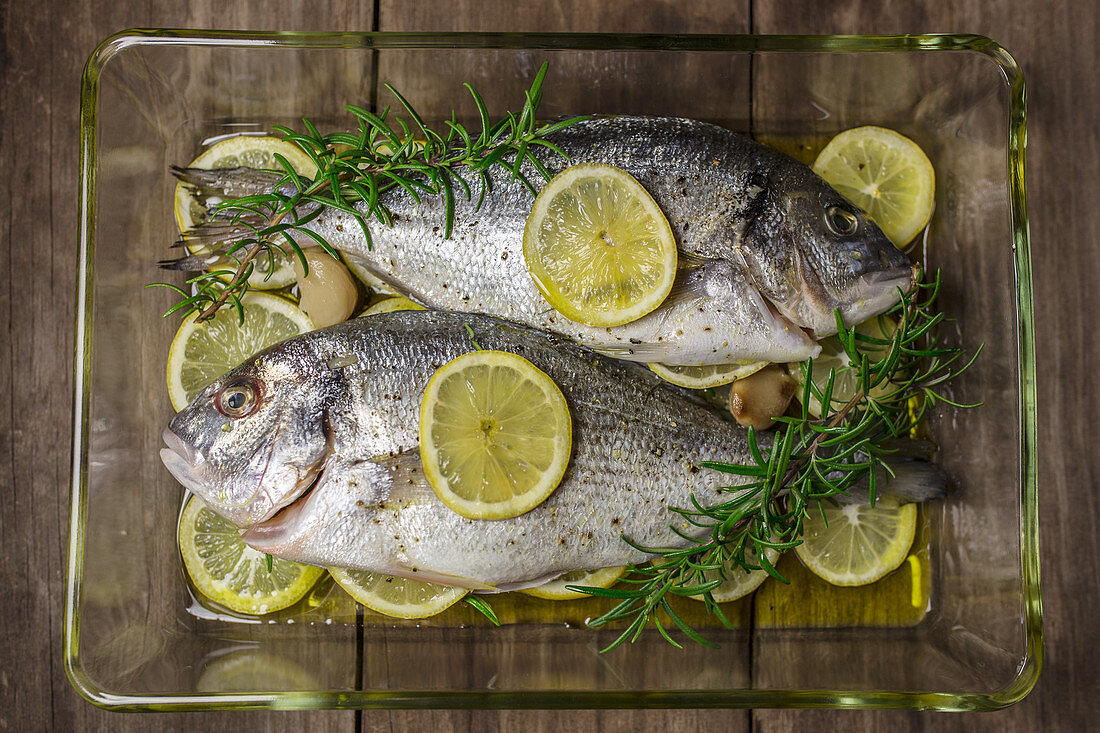 Fresh seabream with lemon slices and rosemary