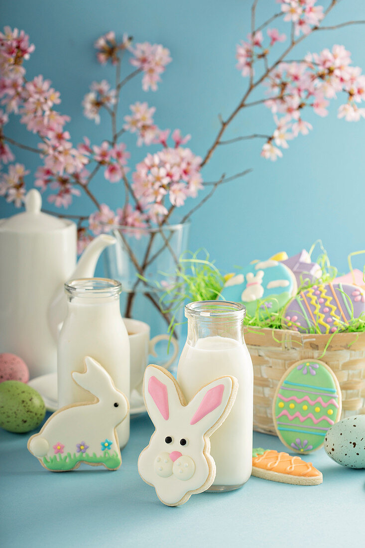 Easter cookies on blue table with milk in little bottles