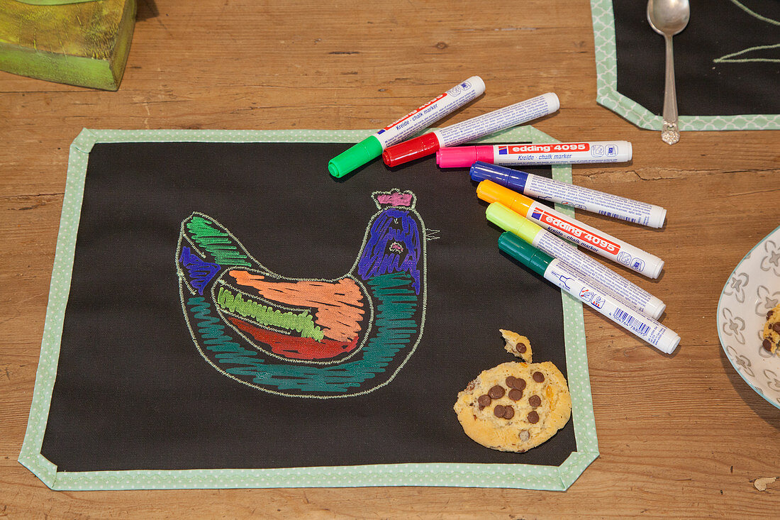 Colourful chicken drawn on place mat made from chalkboard fabric