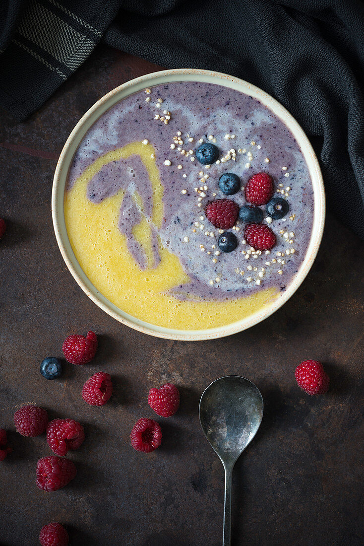 A blueberry and mango smoothie bowl with fresh fruits and popped amaranth (vegan)