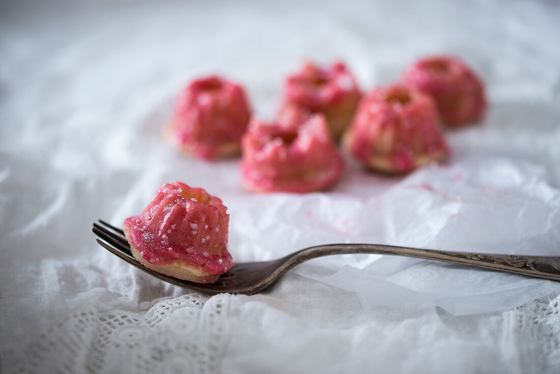Minigugelhupf mit pinkfarbenem Zuckerguss und essbarem Glitzerdekor