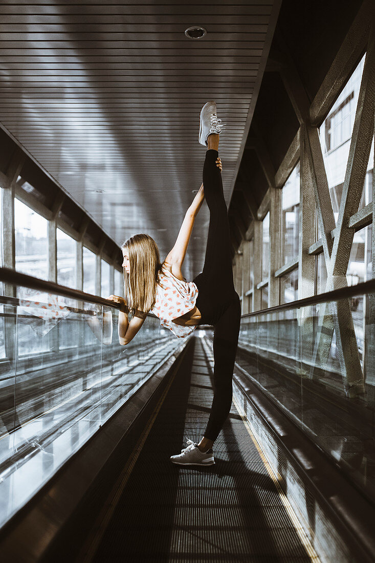 Caucasian woman dancing on moving walkway