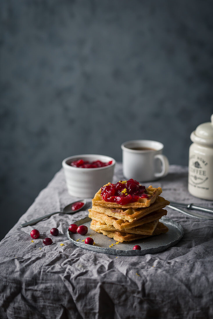 Waffeln mit Cranberrysauce auf Frühstückstisch