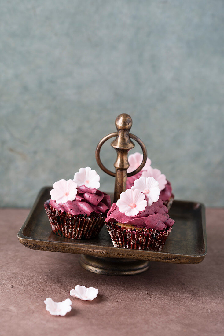 Cupcakes with berry cream and sugar flowers