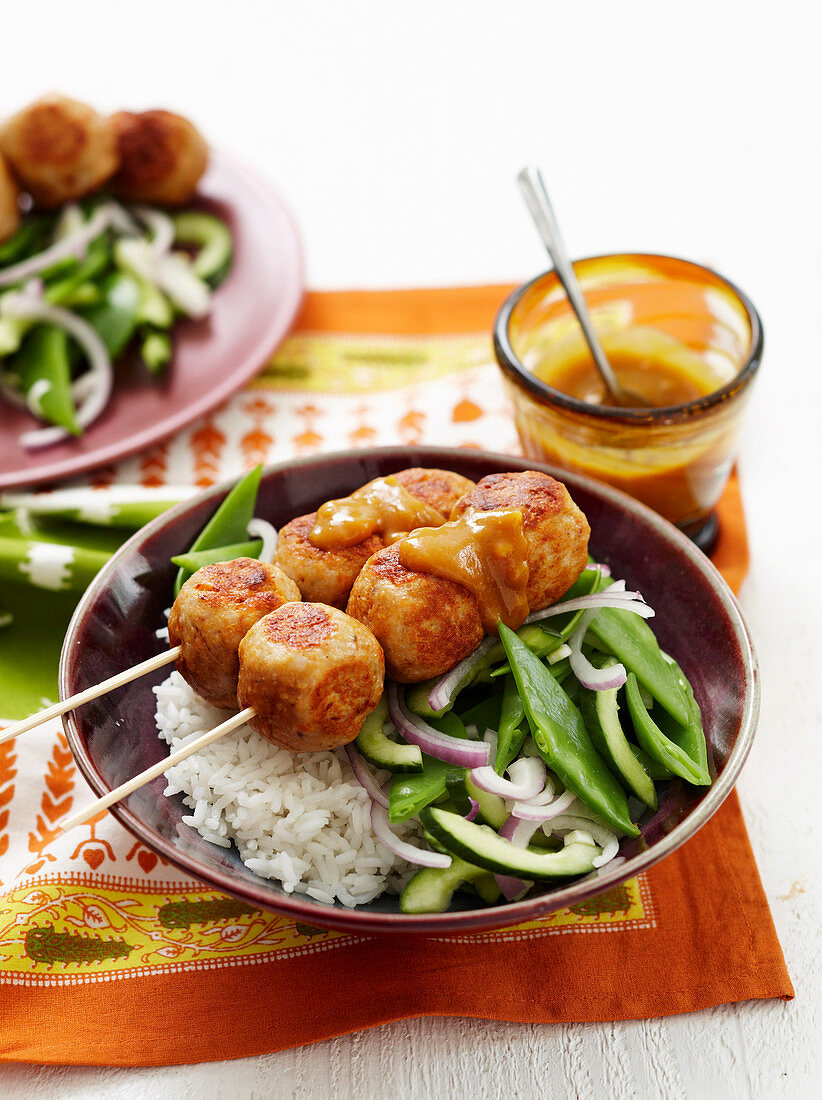 Satay-Hühnerbällchen auf Reis und Bohnen