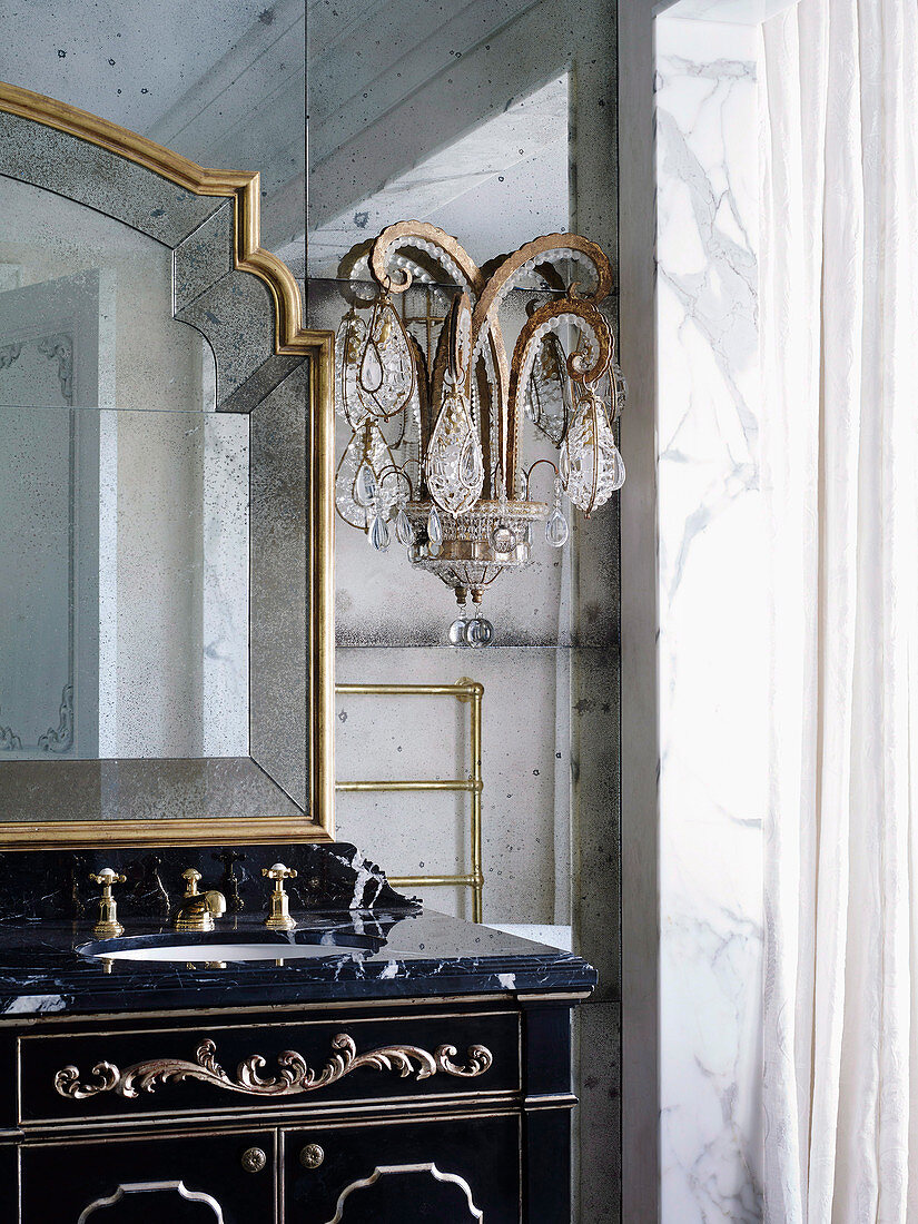 Antique vanity with marble top and crystal lamp in the bathroom in French baroque style