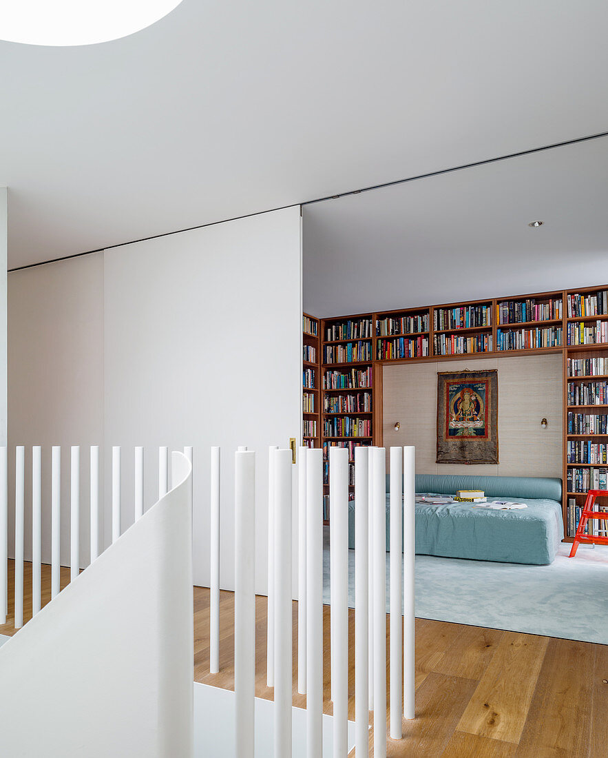 View from the landing to the bedroom with a bookcase around the bed