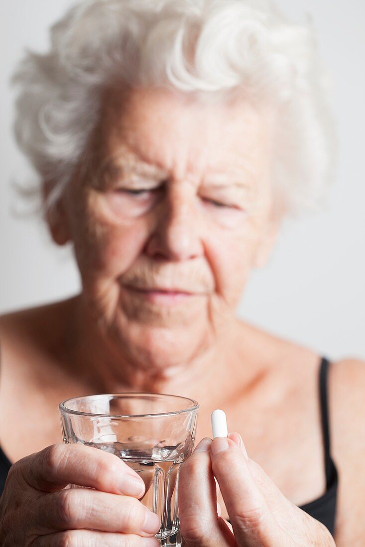 Elderly woman taking a pill