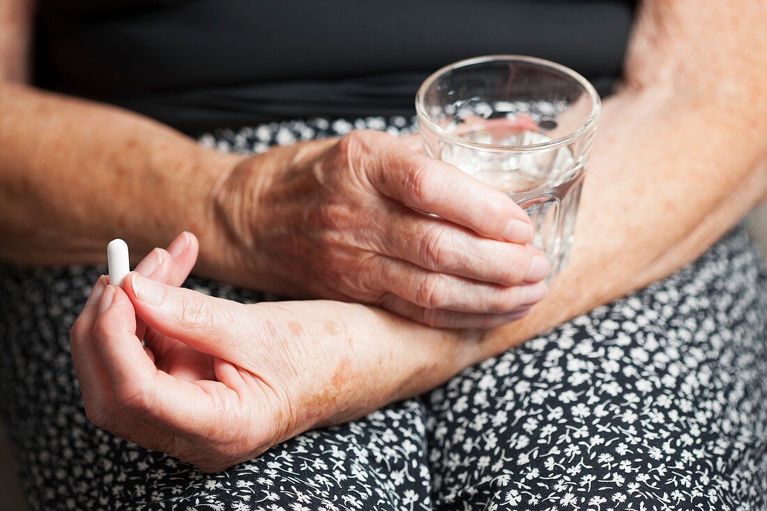 Elderly woman taking a pill