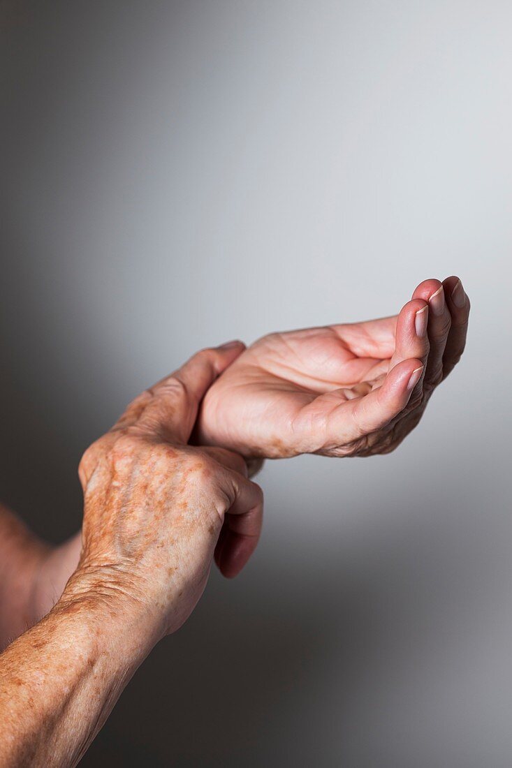 Elderly woman monitoring her wrist pulse