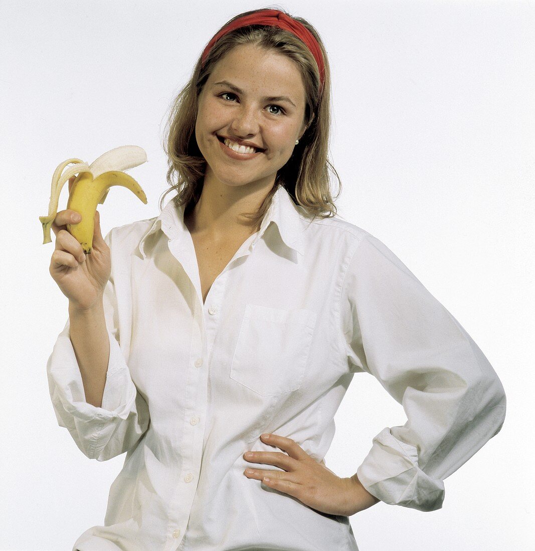 Modell hält eine halbgeschälte Banane