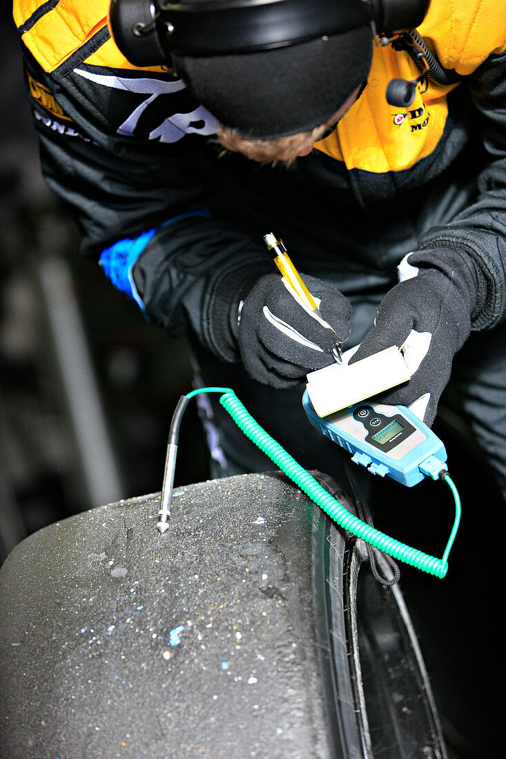 Racing car technician checking tyre temperatures