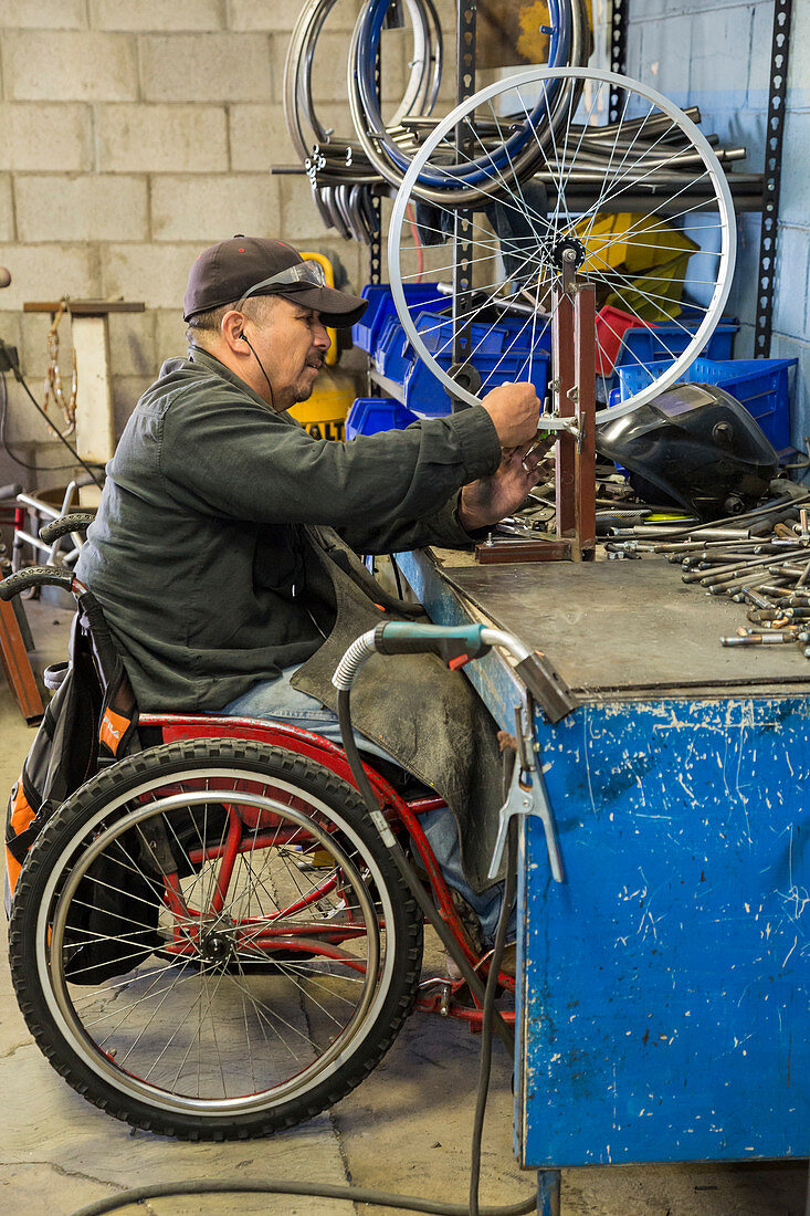 Disabled worker making wheelchair, Mexico