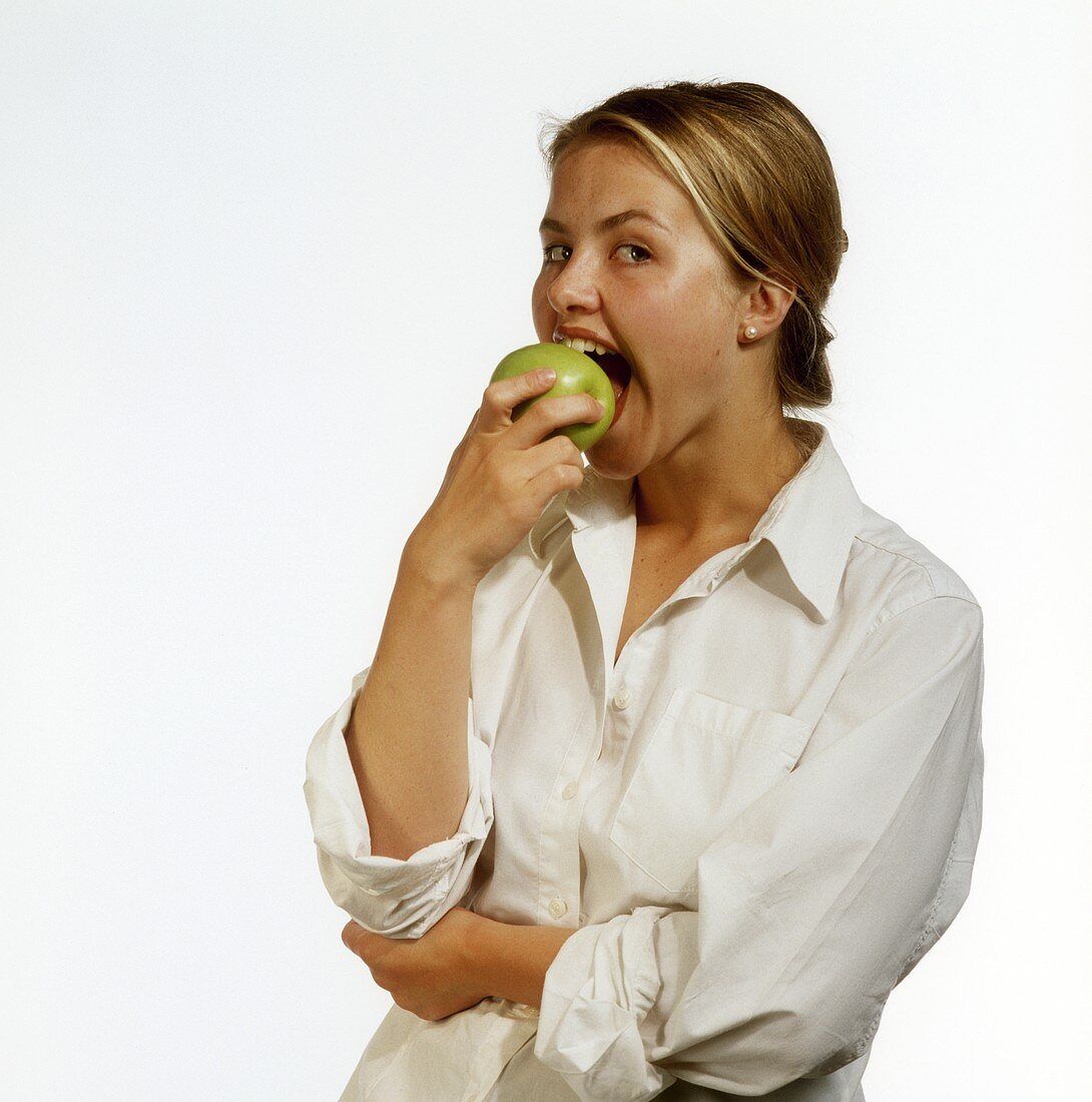 Modell beißt in grünen Apfel