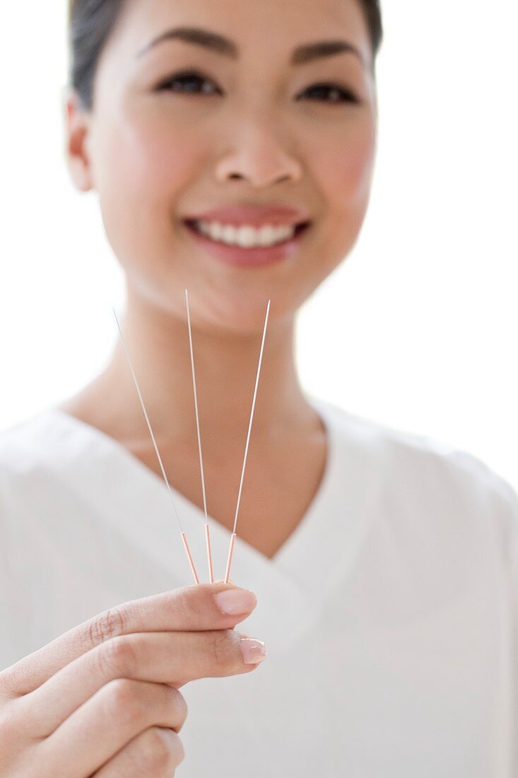 Woman holding acupuncture needles