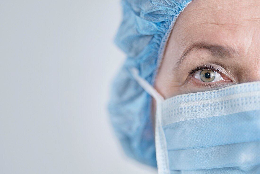 Female surgeon wearing surgical mask and cap