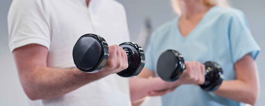 Nurse showing man how to use hand weights
