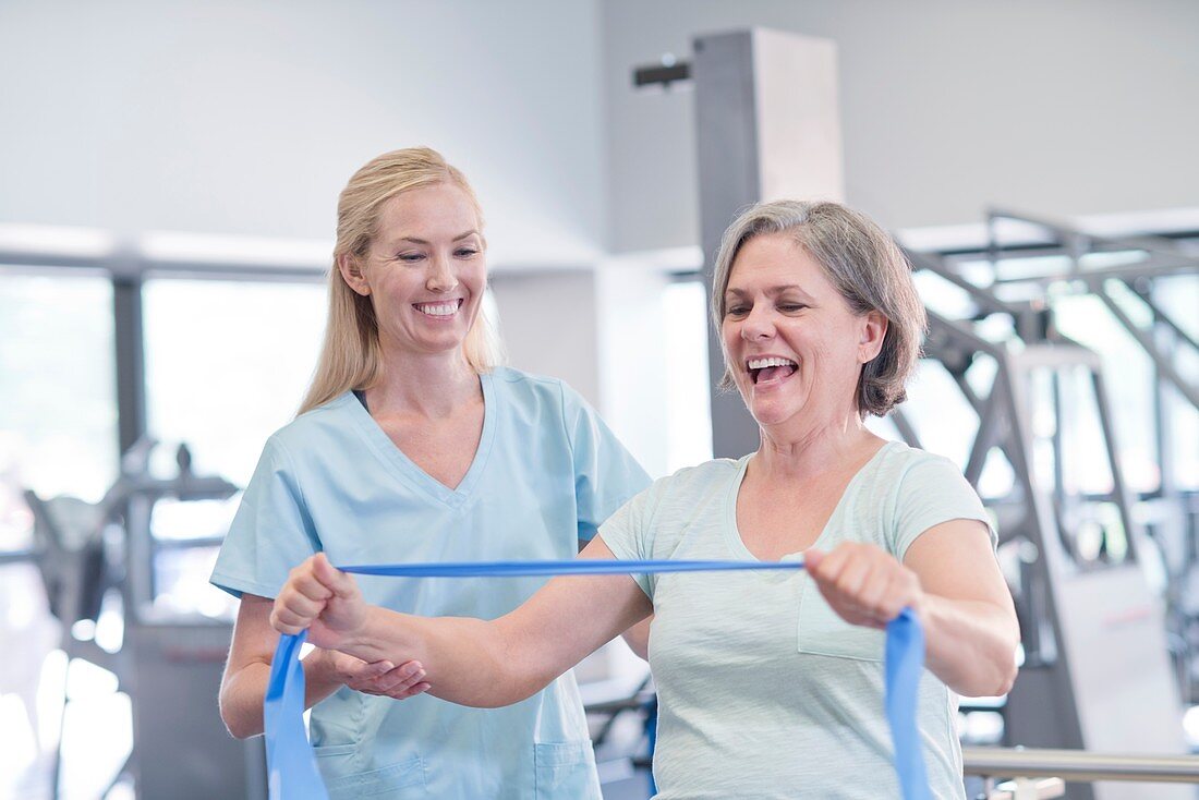 Nurse showing woman how to use resistance band