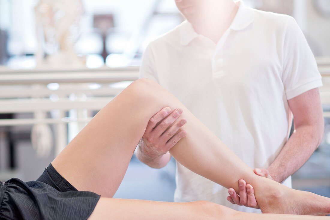 Physiotherapist manipulating woman's leg