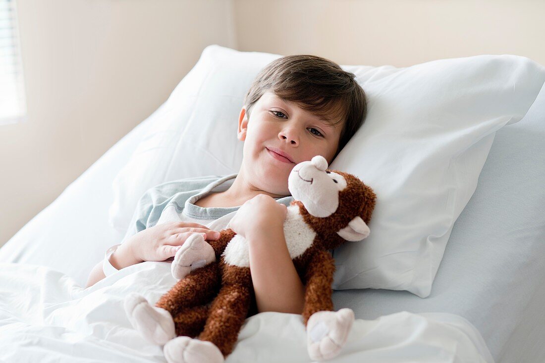 Boy in hospital bed with teddy bear