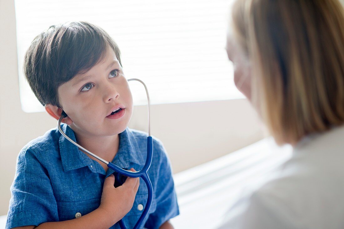Boy wearing stethoscope with nurse