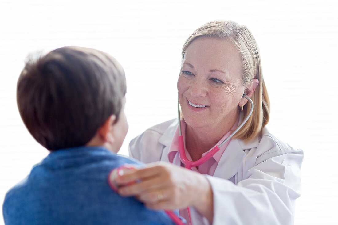 Nurse using stethoscope with Boy