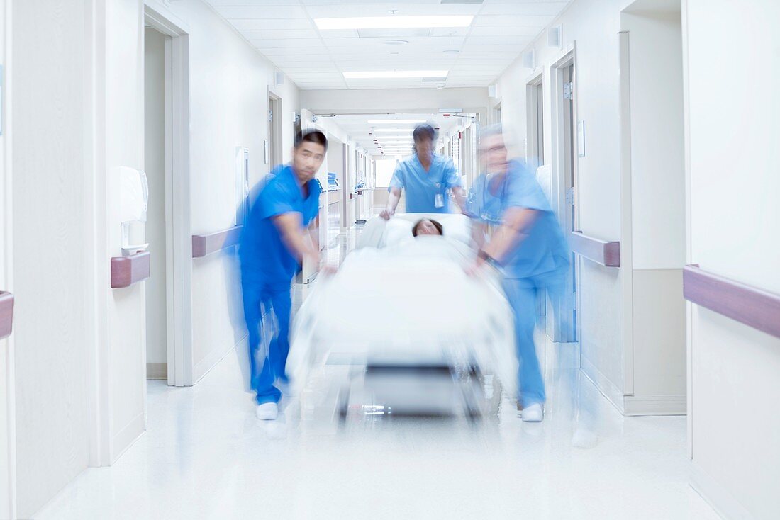 Medical team pushing patient on bed