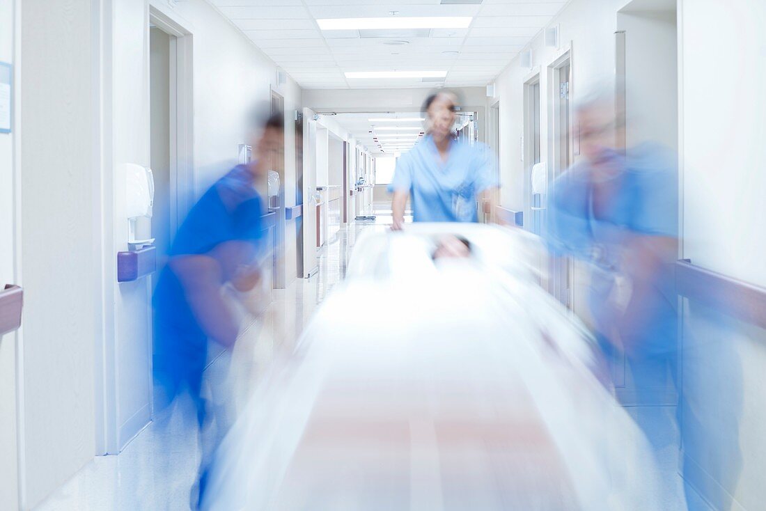 Medical team pushing patient on bed