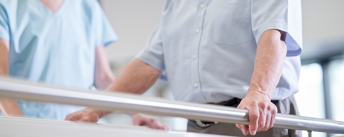Man using parallel walking bars in hospital