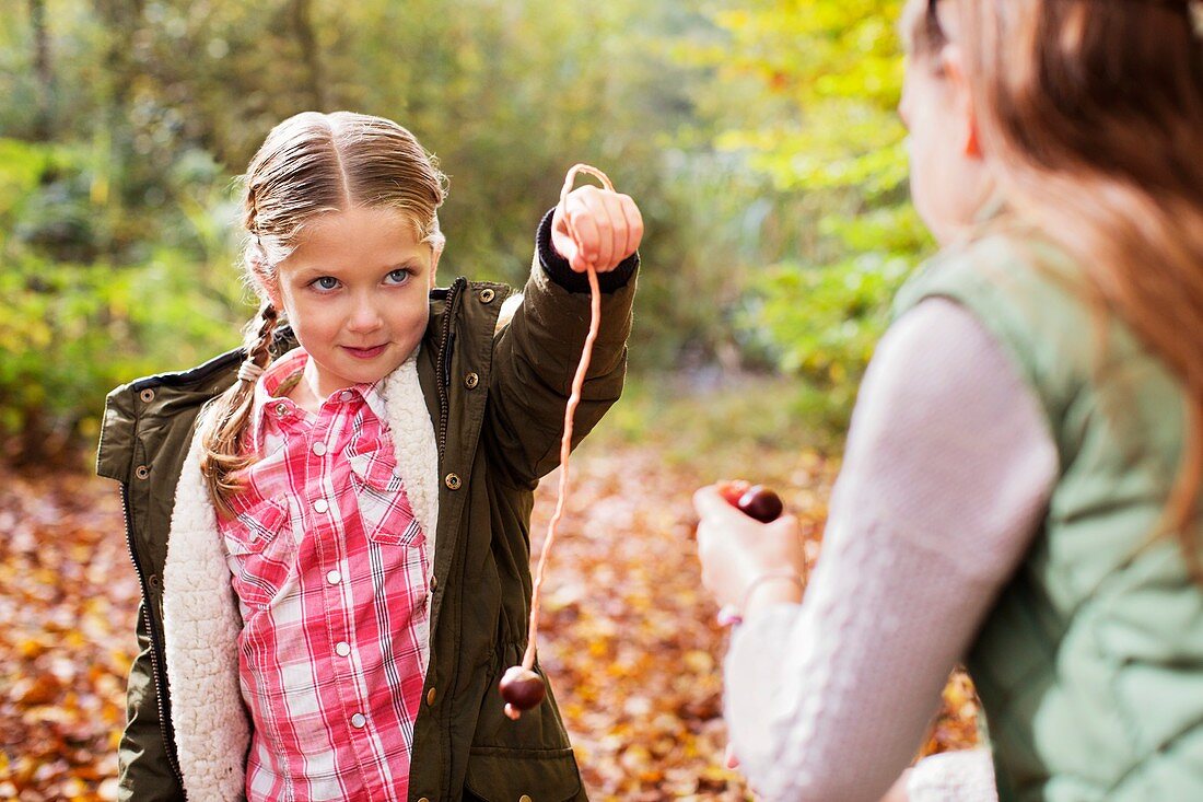 Two girls playing conkers