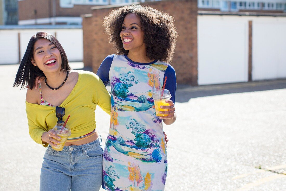 Women with drinks outdoors, laughing