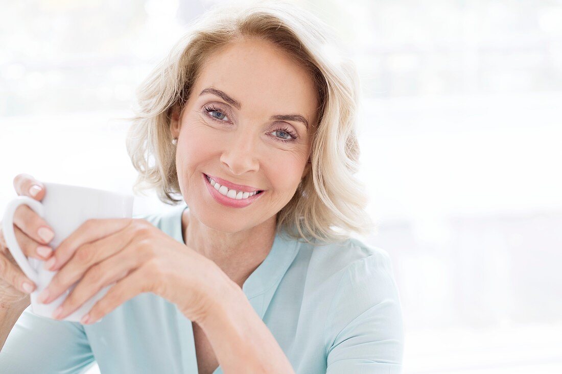 Mature woman smiling with cup of tea