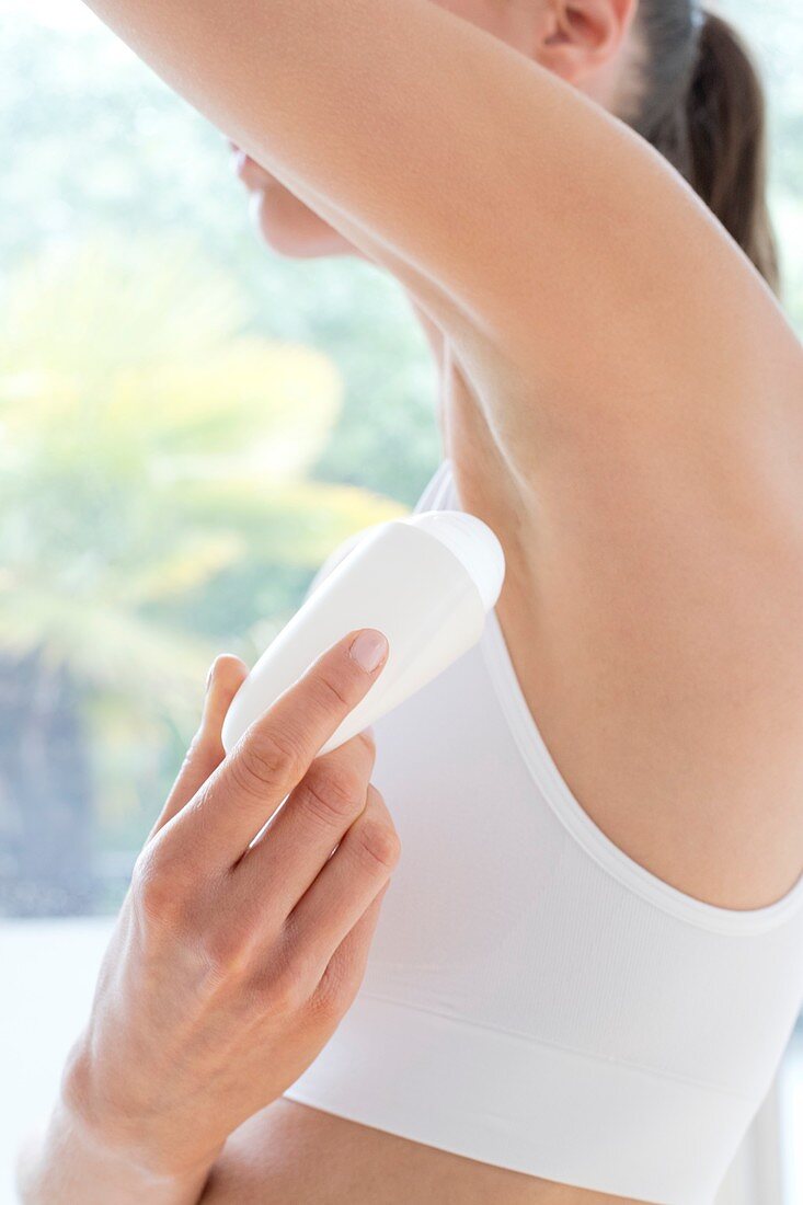 Woman applying underarm deodorant