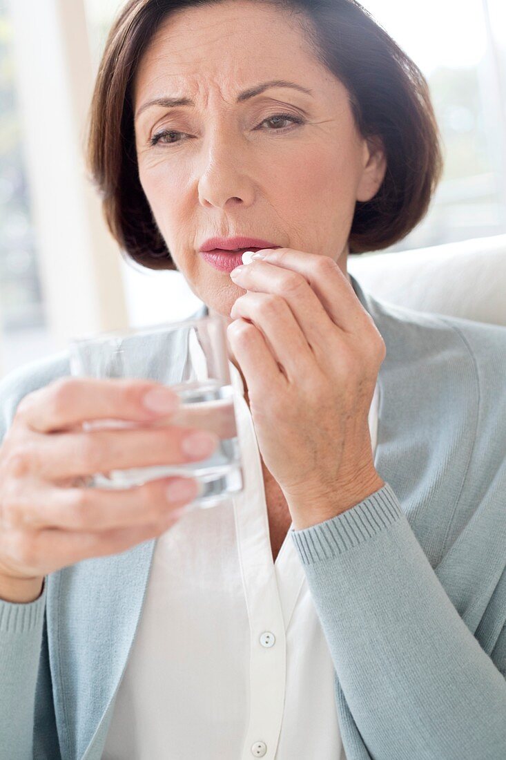 Mature woman taking tablet