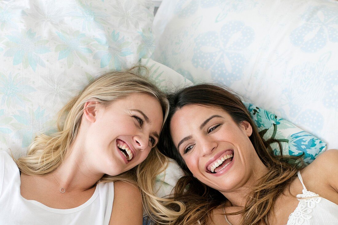 Women lying on bed, smiling