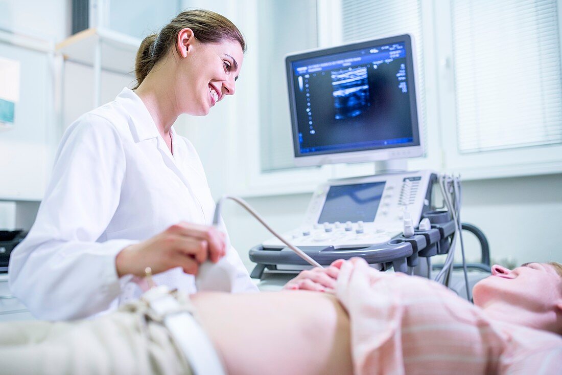 Sonographer performing ultrasound on patient