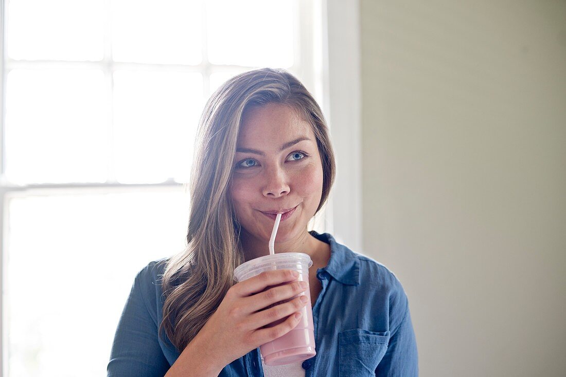 Woman drinking through straw