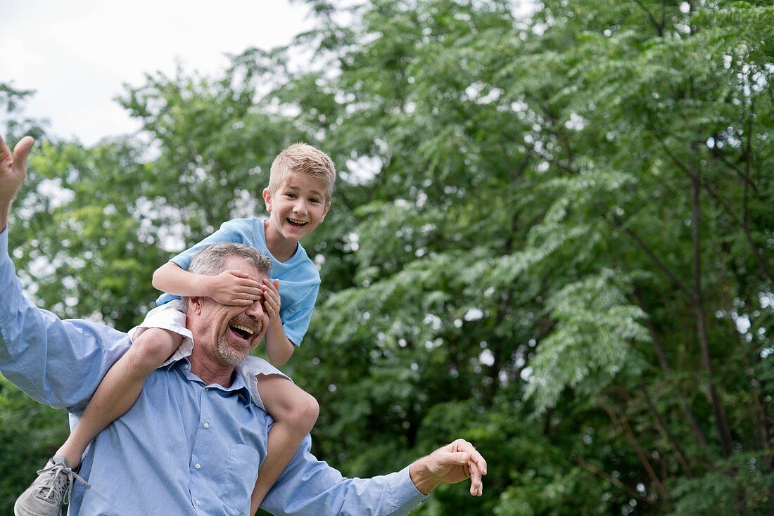 Grandfather carrying grandson on shoulders