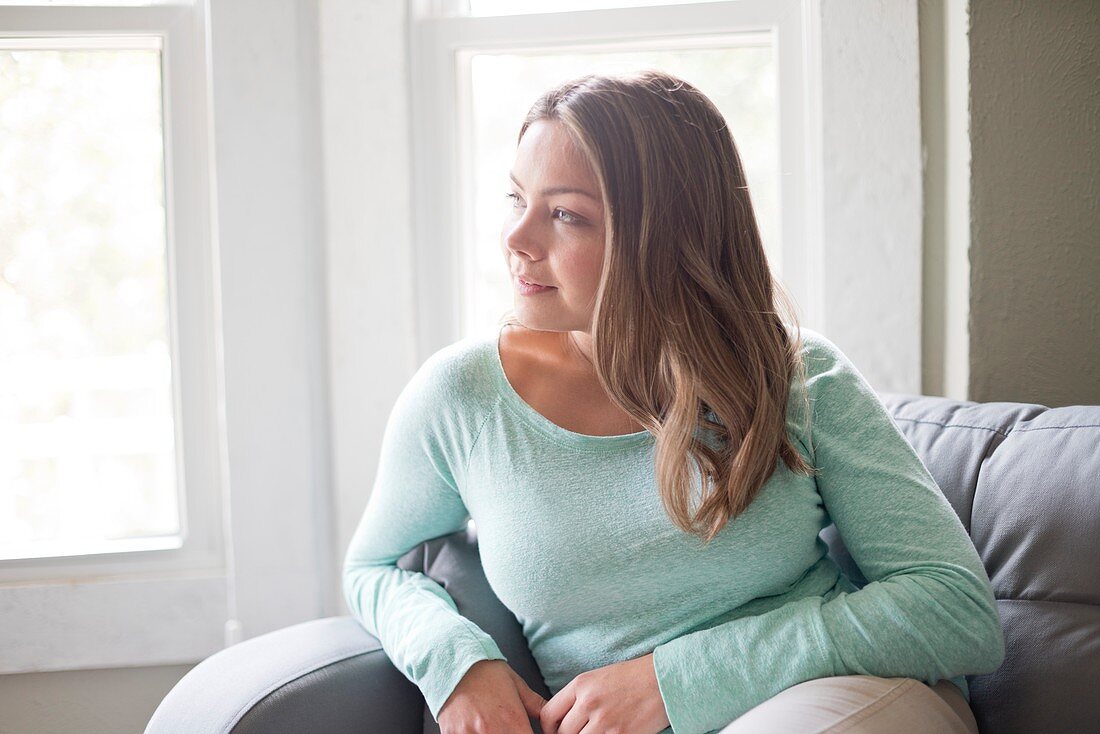 Woman sitting on sofa and looking away