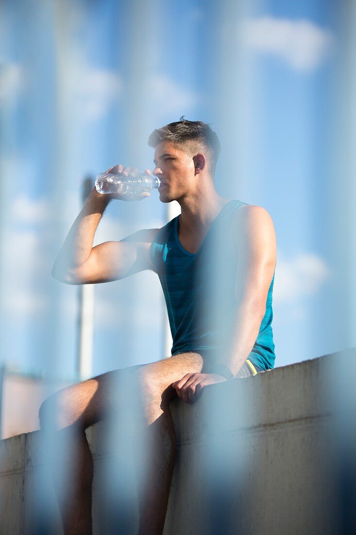 Young man drinking bottle of mineral water