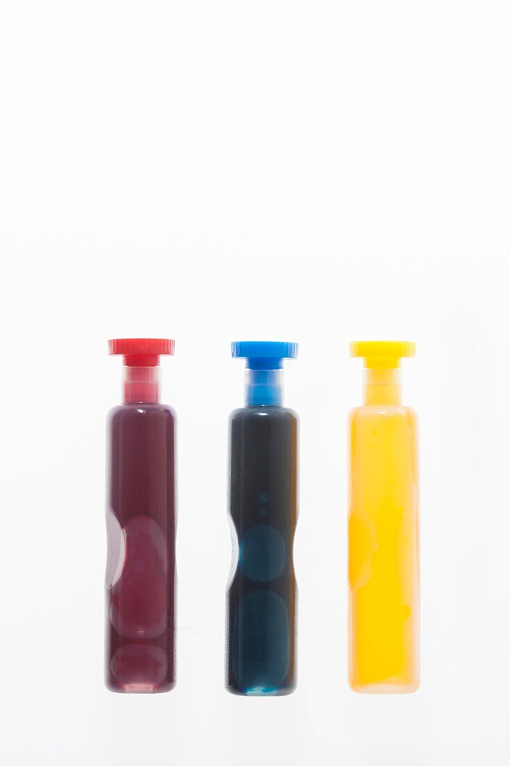 Three containers with coloured liquid