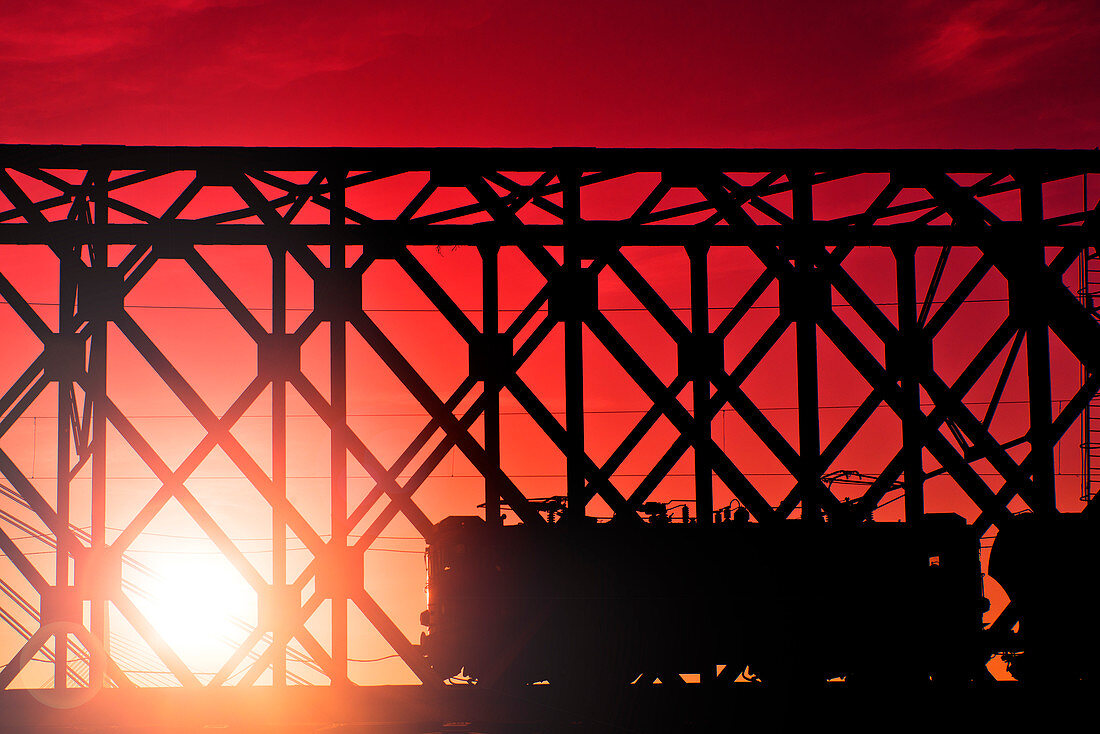 Train crossing bridge at sunset