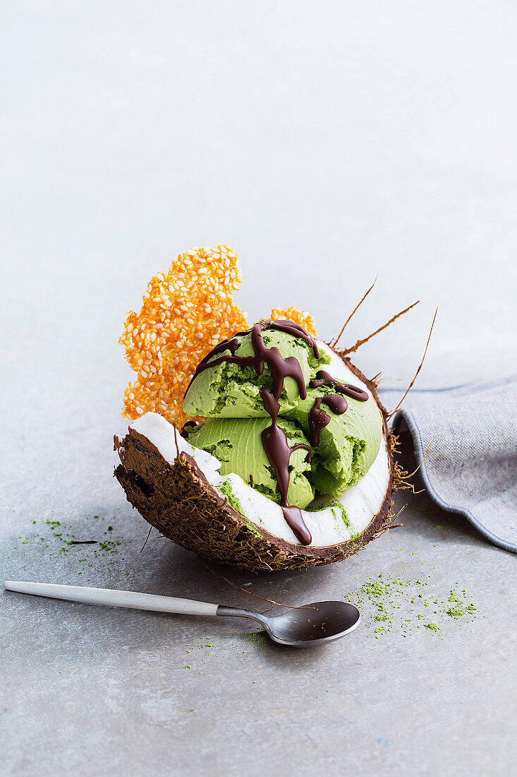 Kokos-Matcha-Eis mit Sesamkrokant in der Kokosnuss