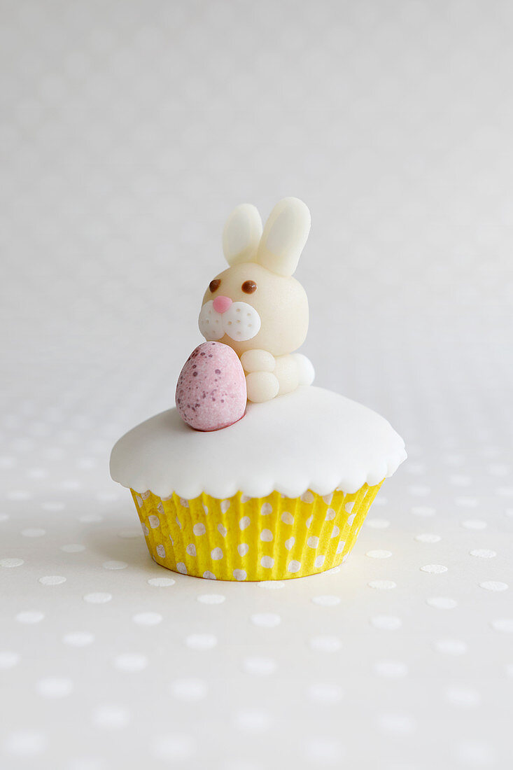 An Easter cupcake with a marzipan bunny and a chocolate egg