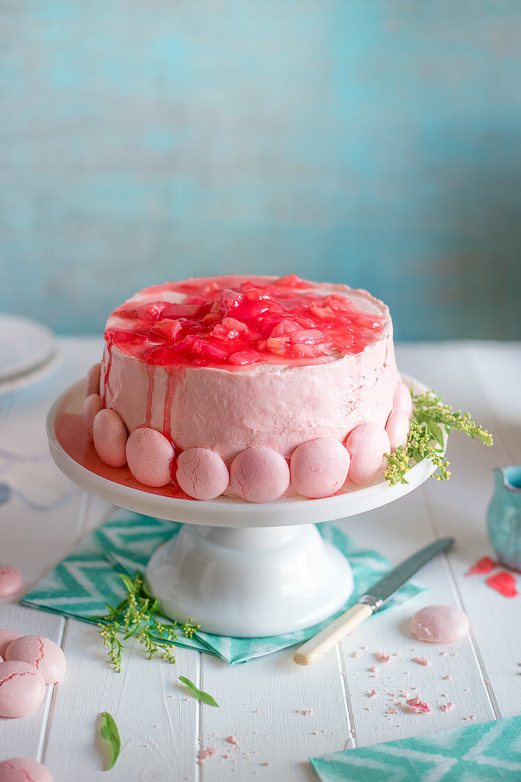 Rhabarberkuchen mit Schweizer Buttercreme und rosa Meringue auf Kuchenständer