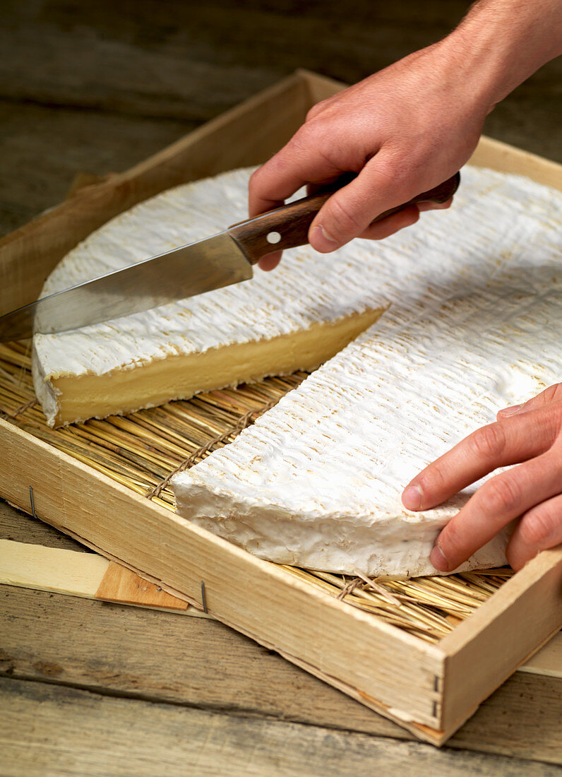 Einen Brie in Stücke schneiden
