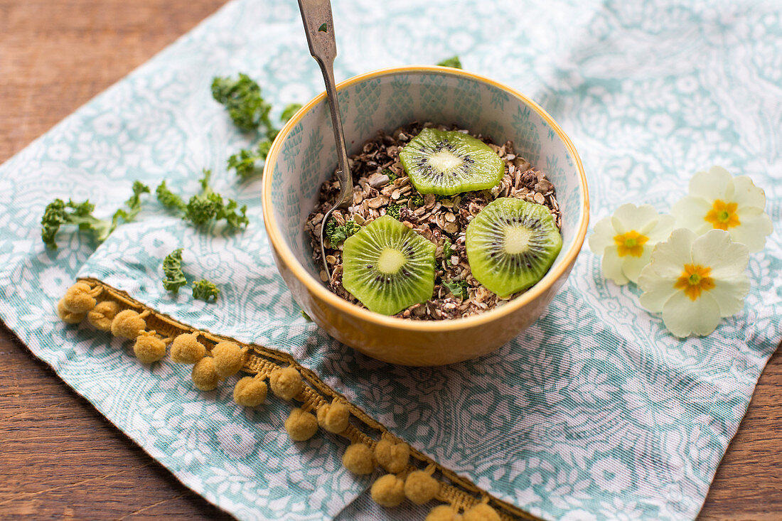 Bowl of muesli with kiwi and kale